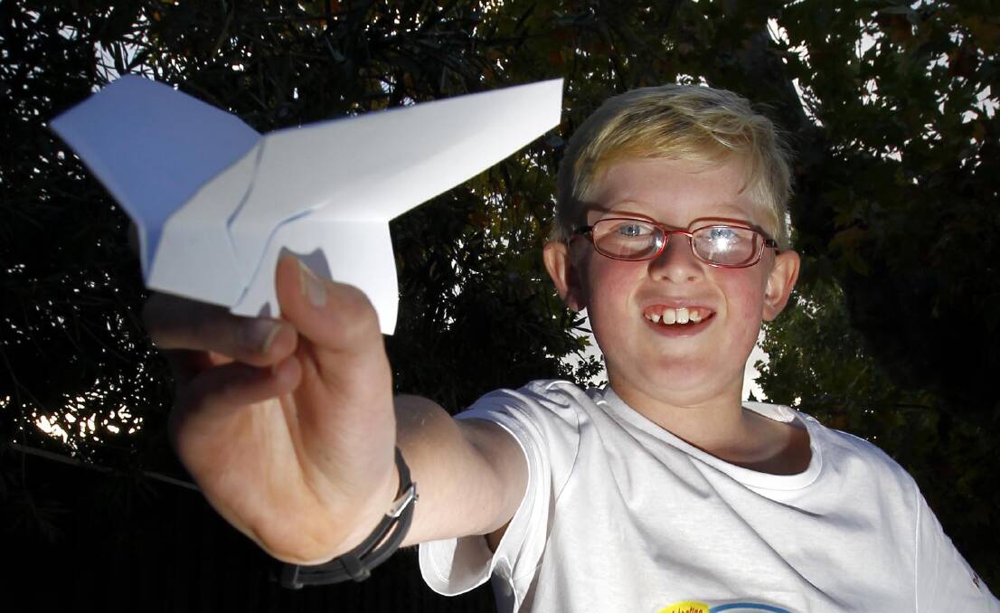 HIGH FLYER: Harry Pratt, 10, from Illabo, shows off thedesign of paper plane which landed him a state title this week. Picture: Les Smith
