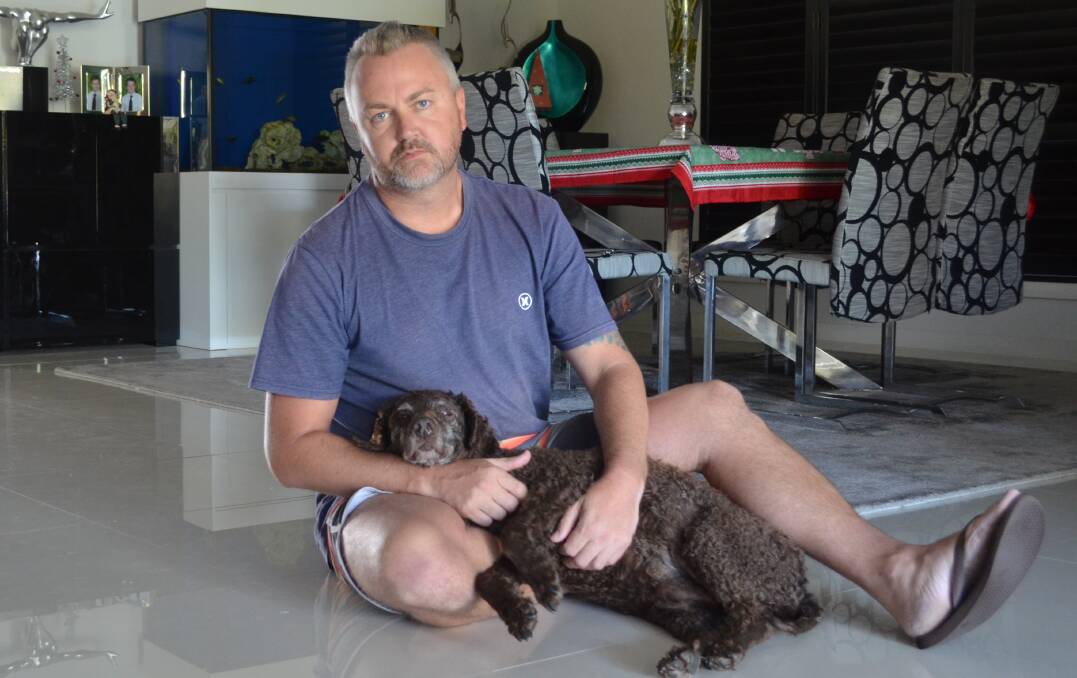 DISTRAUGHT: Nathan Wilson with his curly haired retriever, Charlotte, at their Fern Bay home. Picture: Sam Norris 