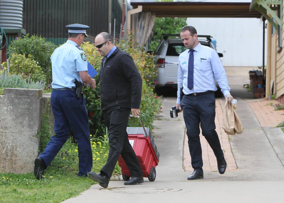 EVIDENCE TAKEN: Police carry evidence out of the Junee home of a former teacher, who is facing allegations of historic child sex abuse. Pictures: Les Smith 