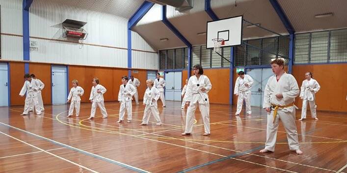 HIGH KICKS: Fourteen Junee Tae Kwon Do students passed their grading on Monday night at the Junee High School auditorium. Many were at the group's very first training session in March. Picture: Supplied