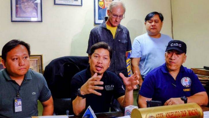 Alleged Australian sex offender Peter Gerard Scully stands behind Philippines police investigator Angelito Magno. Photo:  Bobby Lagsa/Inquirer