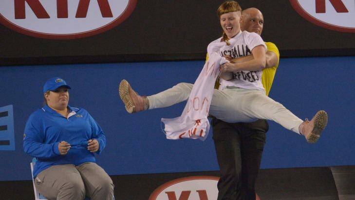 A protester is removed from centre court. Photo: Joe Armao