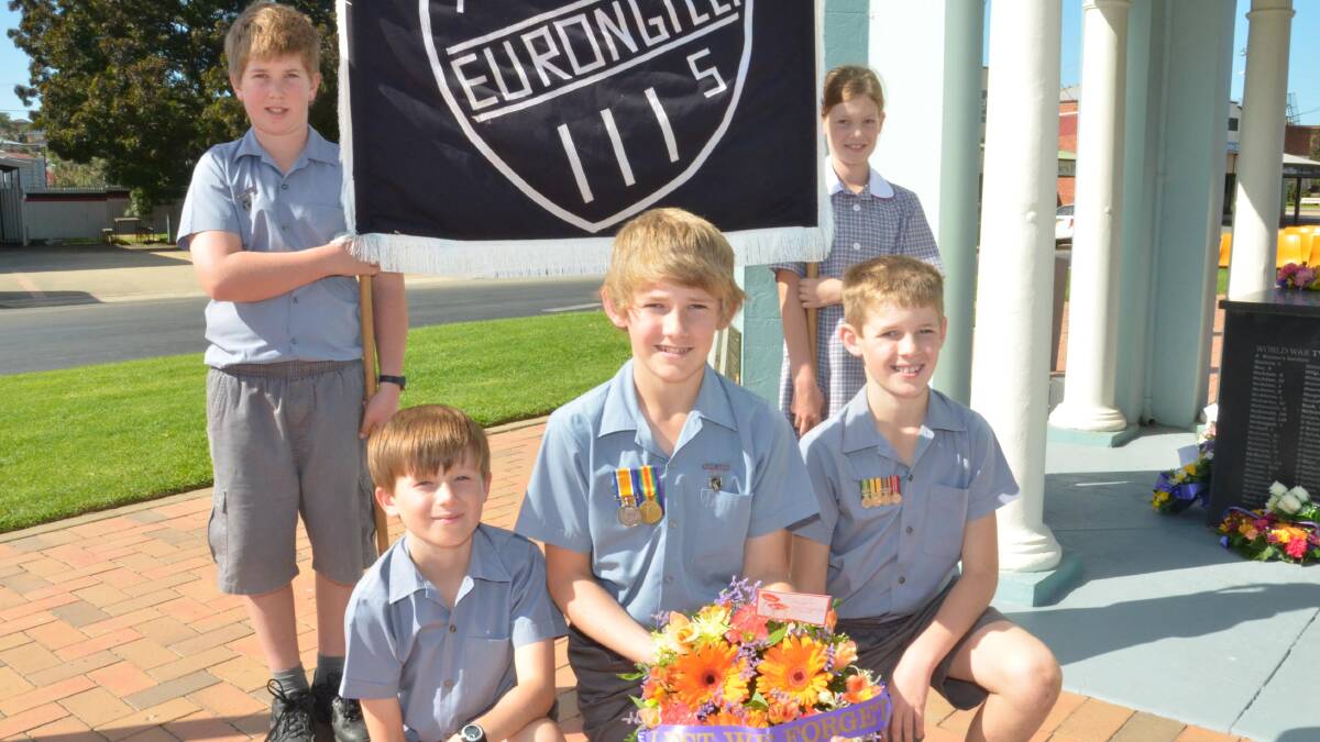 Anzac day in Junee. Eurongilly Public School students Angus Herbert, 12, and Claire Herbert, 9, holding the sign with Henry Matear, 10, Jarrod MacLeod, 12, and Rhauri MacLeod, 10. Picture: Declan Rurenga