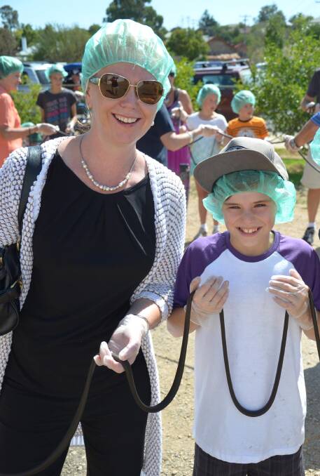 Jennifer Roep and Harry McEwen, 11, take part in the world's longest licorice strap attempt. Picture: Declan Rurenga