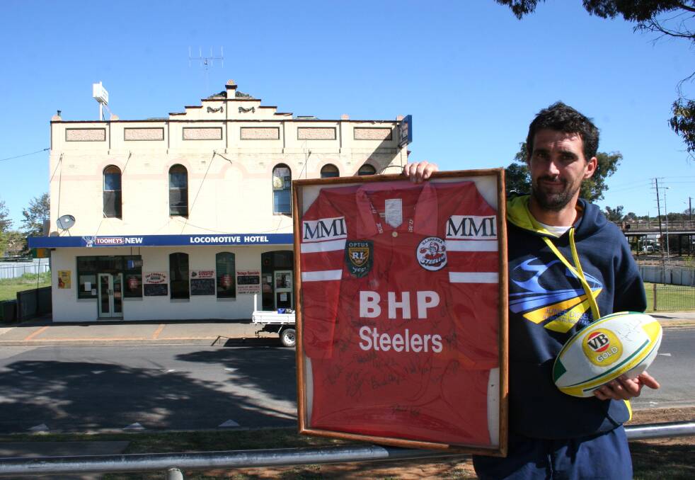 Locomotive Hotel Licensee Damien Field with some of the football memorabilia that will be availabe at the hotel's family fun day to help raise money for Junee Can Assist. Picture: Declan Rurenga
