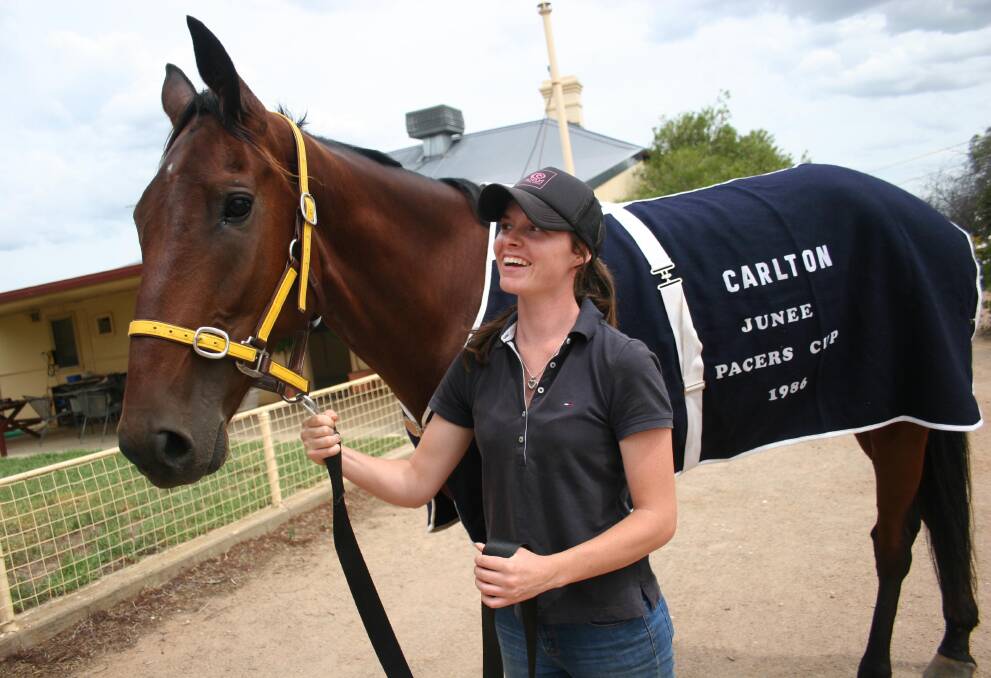 Stablehand Sarah White and the Trevor White trained Hollywood Sign share a moment ahead of Sunday's Junee Pacers Cup. Picture: Declan Rurenga