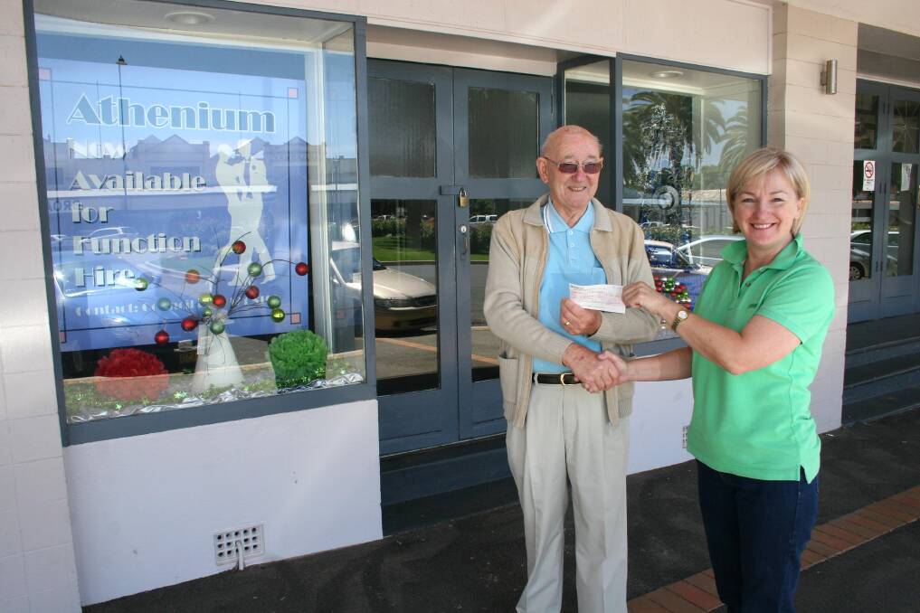 Friends of the Athenium committee member Roger Quine &#7;presents a $700 cheque to Cooinda Court management committee president Patricia Butler. The majority of the funds are proceeds from a raffle held during the official opening of the Athenium. Picture: Declan Rurenga