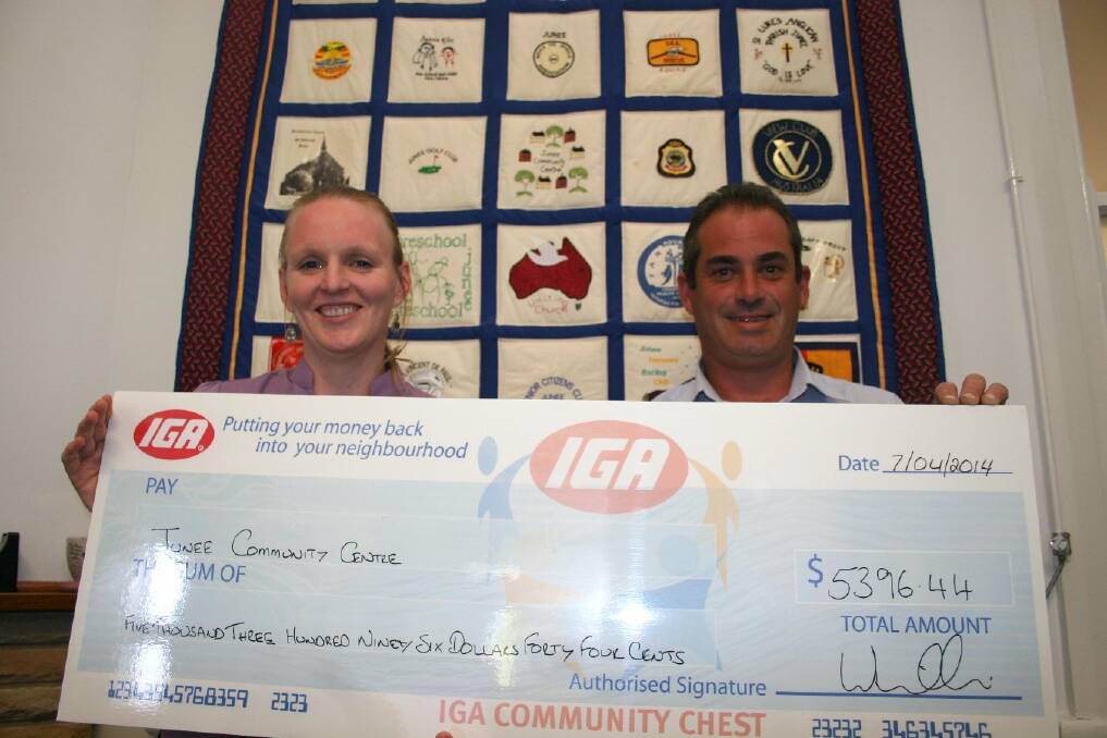 Junee Community Centre manager Amy Murphy is presented with a cheque by IGA store manager Shane Willis to help with the centre's programs. Picture: Declan Rurenga