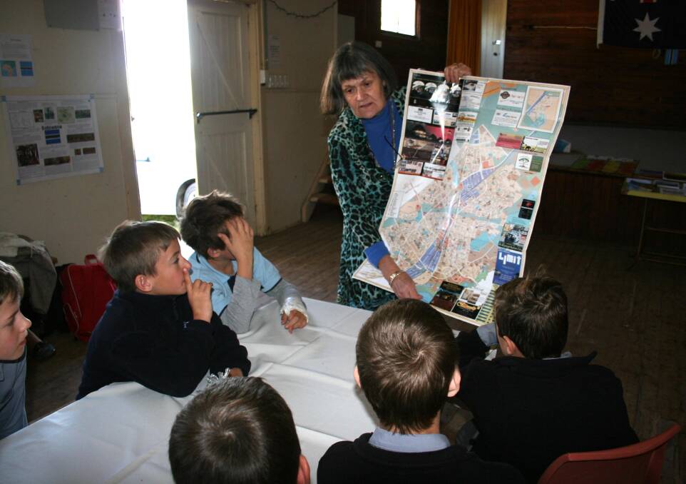 Canberra resident Jane Holden shows students from Eurongilly and Nangus public schools a map of one of Botswana’s cities during the Eurongilly CWA’s international day.