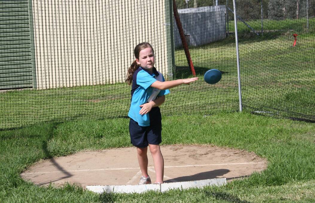 Anabelle Willis, 7 gets the discus moving forward. Picture: Declan Rurenga