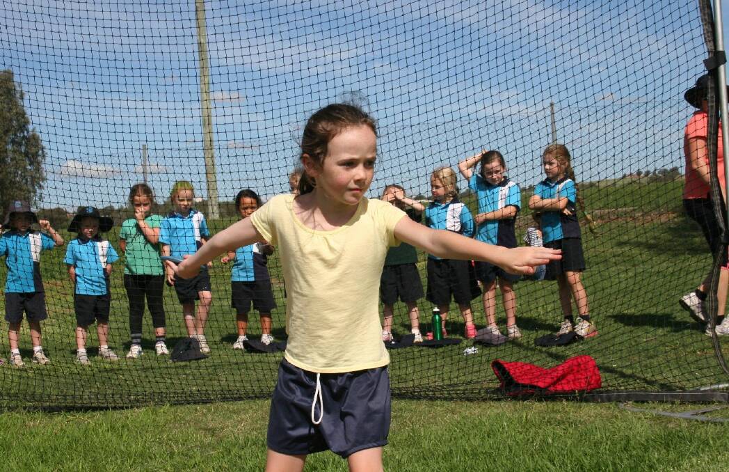 Chelsea Crowder, 7 practises her throw during the discus competition. Picture: Declan Rurenga