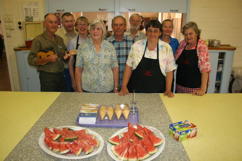 Junee's Open Kitchen volunteers (from left) Brian Beasley, Ian Holland, Carole Windsor, Val Robinson, Jeff Windsor, Kevin Harris, Karen Heness, Debbie Edmundson and Norma Higginson get ready to serve up dessert on Monday after being recognised with an Australia Day award. Picture: Declan Rurenga