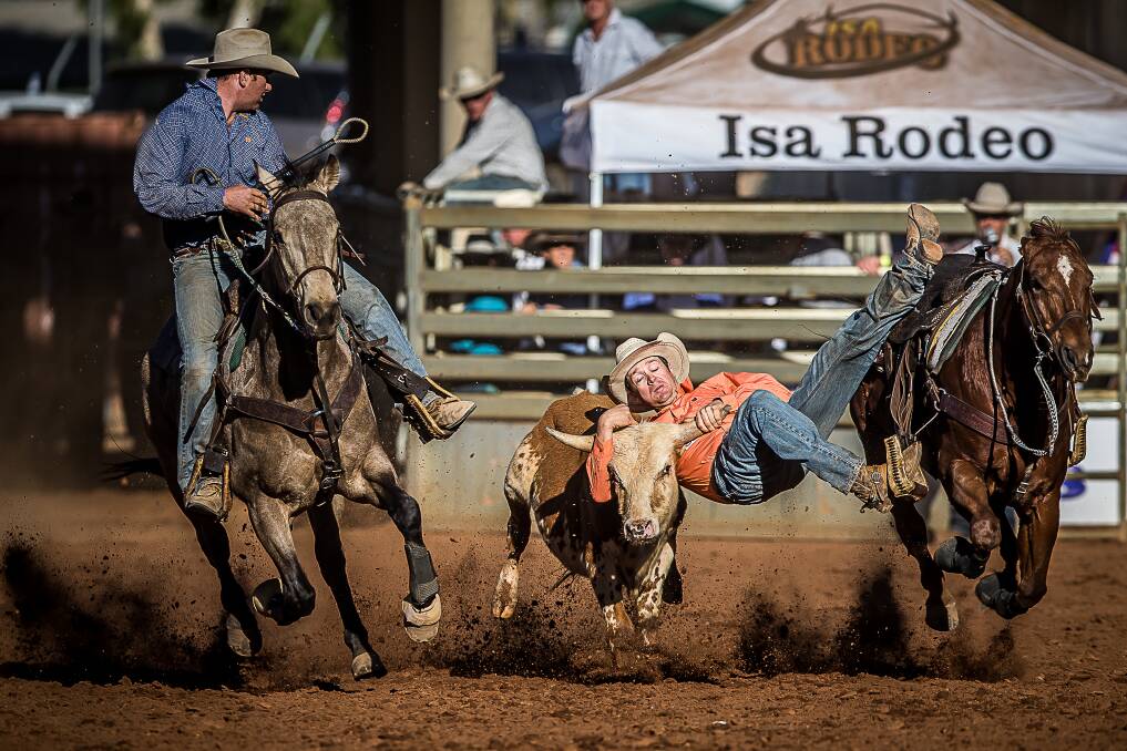 Matt Hedlund wrestles with a steer during the Mount Isa Rodeo while his brother Jack rides along in support. Picture: Steve Mowbray