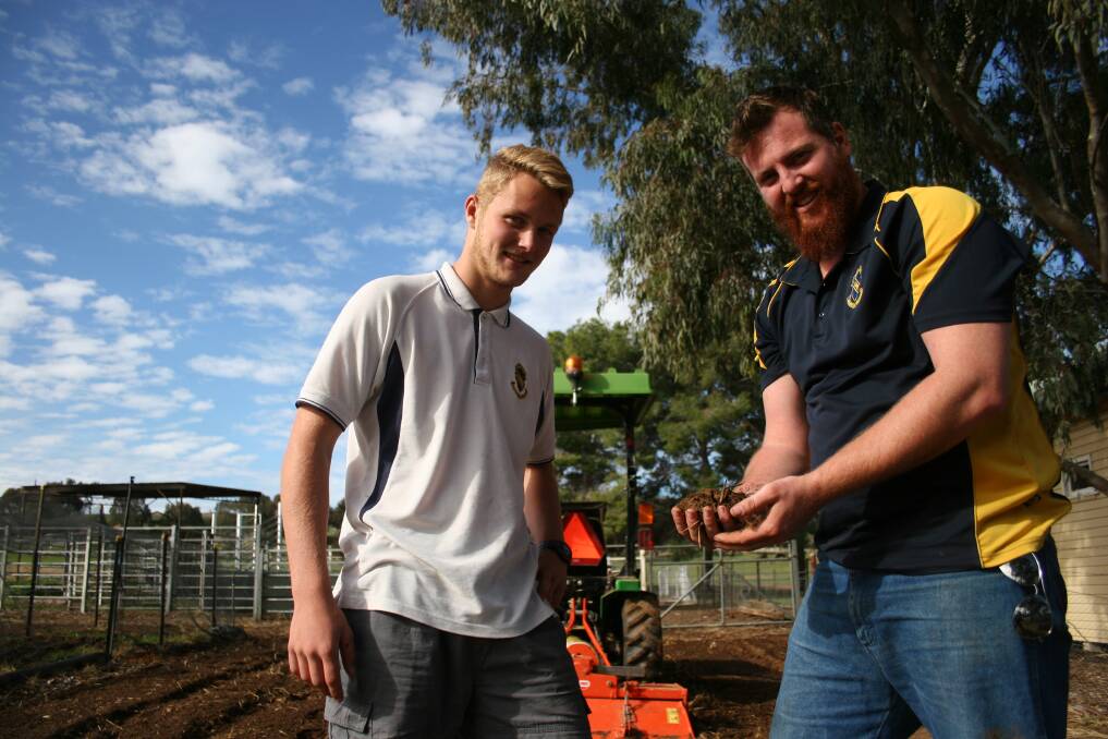 GOOD DIRT: Primary industries student Brad Johnson, 17 and agricultural teacher Paul Anderson examine the soil in the school's farm. Picture: Declan Rurenga