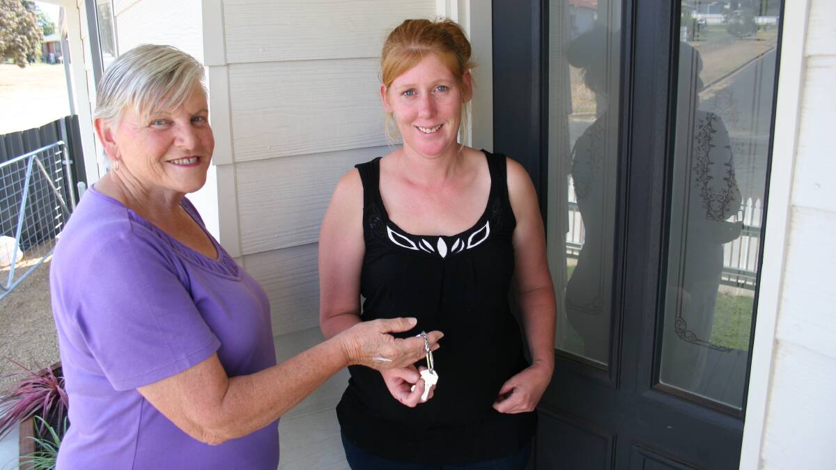 PLACE TO GROW: Habitat for Humanity's Liz Evers hands over the keys for the organisation's third home in Junee to Marie Henderson. Picture: Declan Rurenga