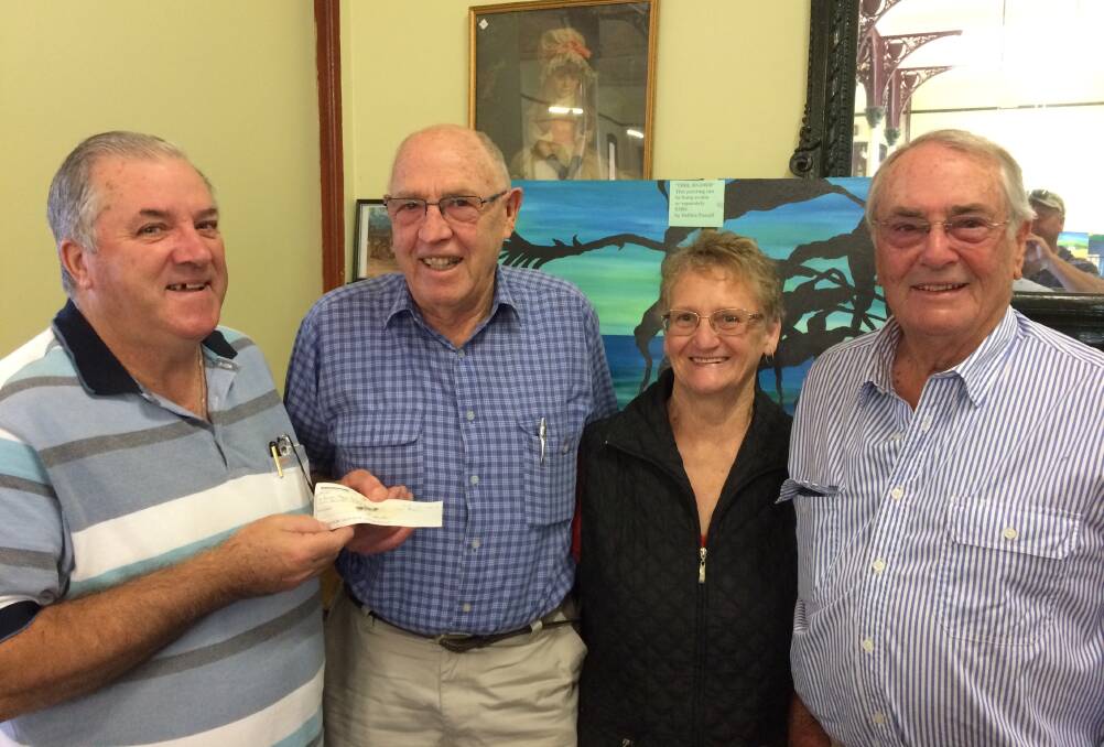 Junee Clay Target Club's Bill Hulm (left) and Doug Metzler (right) receive a cheque from Peter and Margaret Knight for a new perpetual trophy.