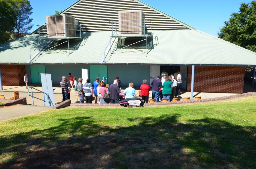 WAITING TO VOTE: Voters start to line up before lunch at the Junee polling place on Saturday for the NSW election. Picture: Declan Rurenga