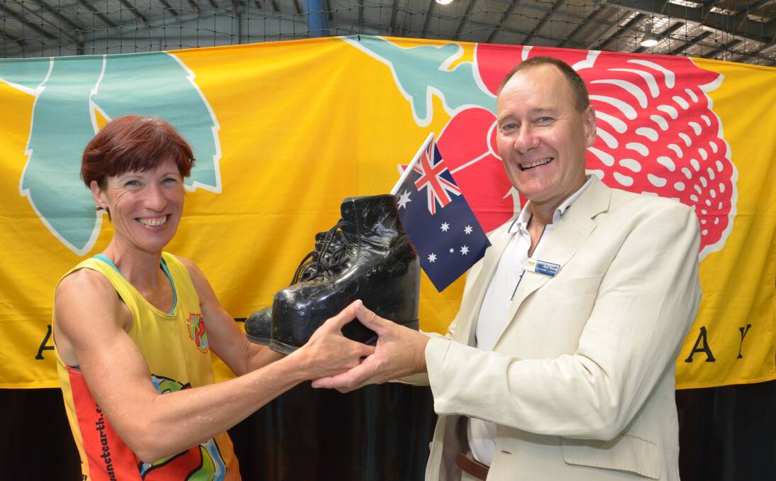GOOD SOULS: Junee mayor Neil Smith hands over a pair of shoes to marathon runner Viv Kartsounis for her charity, Shoes for Planet Earth. Picture: Declan Rurenga