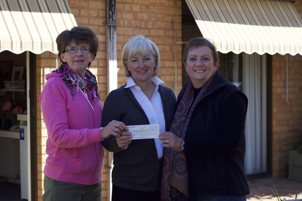 SMALL PAPER, BIG DIFFERENCE: Illabo Melodrama's Jeanne Pratt (left) and Margaret Kanaley hand Cooinda Court's Patricia Butler (centre) a cheque for $5000. Picture: Contributed
