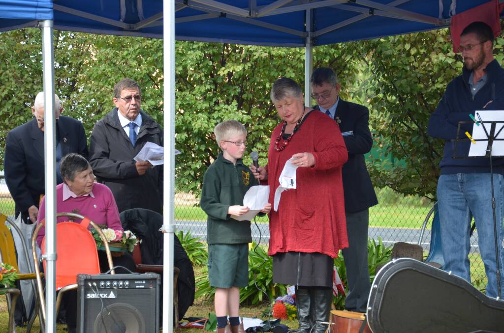 Harry Pratt, 8 reads his poem Red Poppy at the Illabo Anzac Day service. Picture: Declan Rurenga