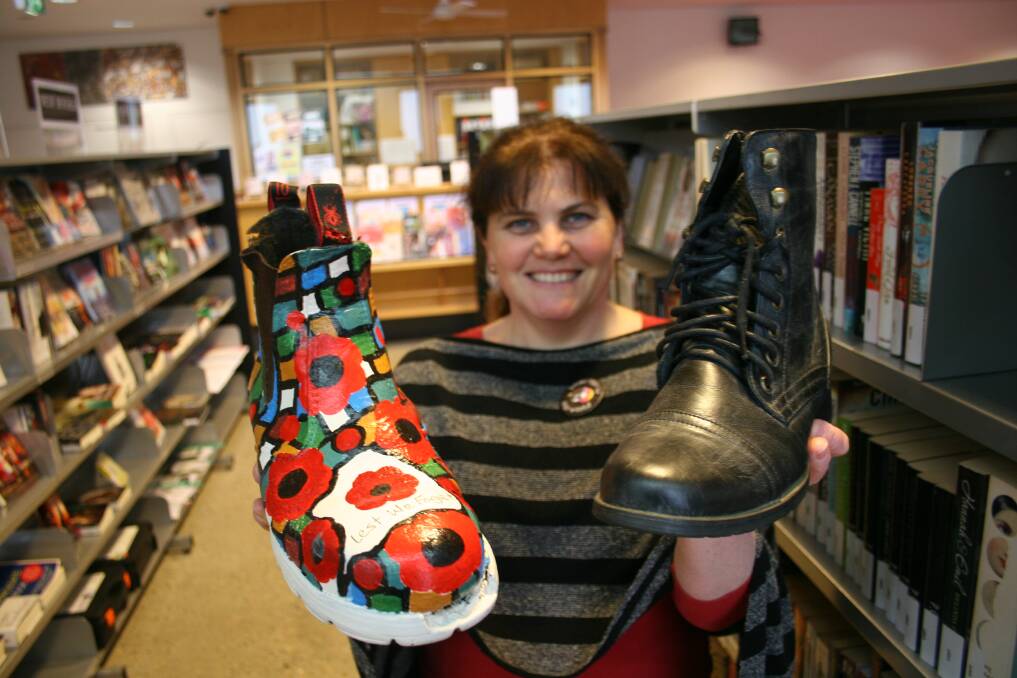 MARCHING BOOTS: Librarian Kim Richards shows off a boot decorated by Junee's Robyn Futcher for the upcoming Kangaroo March. Picture: Declan Rurenga