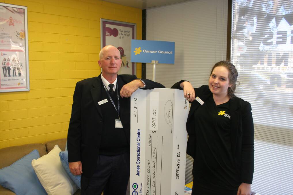 GEO Group's offender services manager Trevor Coles from Junee Correctional Centre presents a $1000 cheque on behalf of inmates to Brianna Carracher from the NSW Cancer Council. Picture: Declan Rurenga