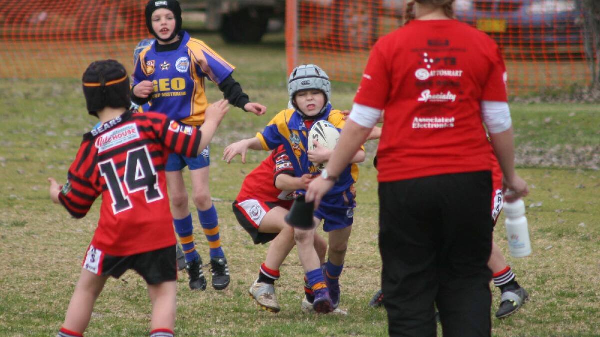 Alex McGregor tries to fend the North Canberra Bears player off in Under 6-7s.