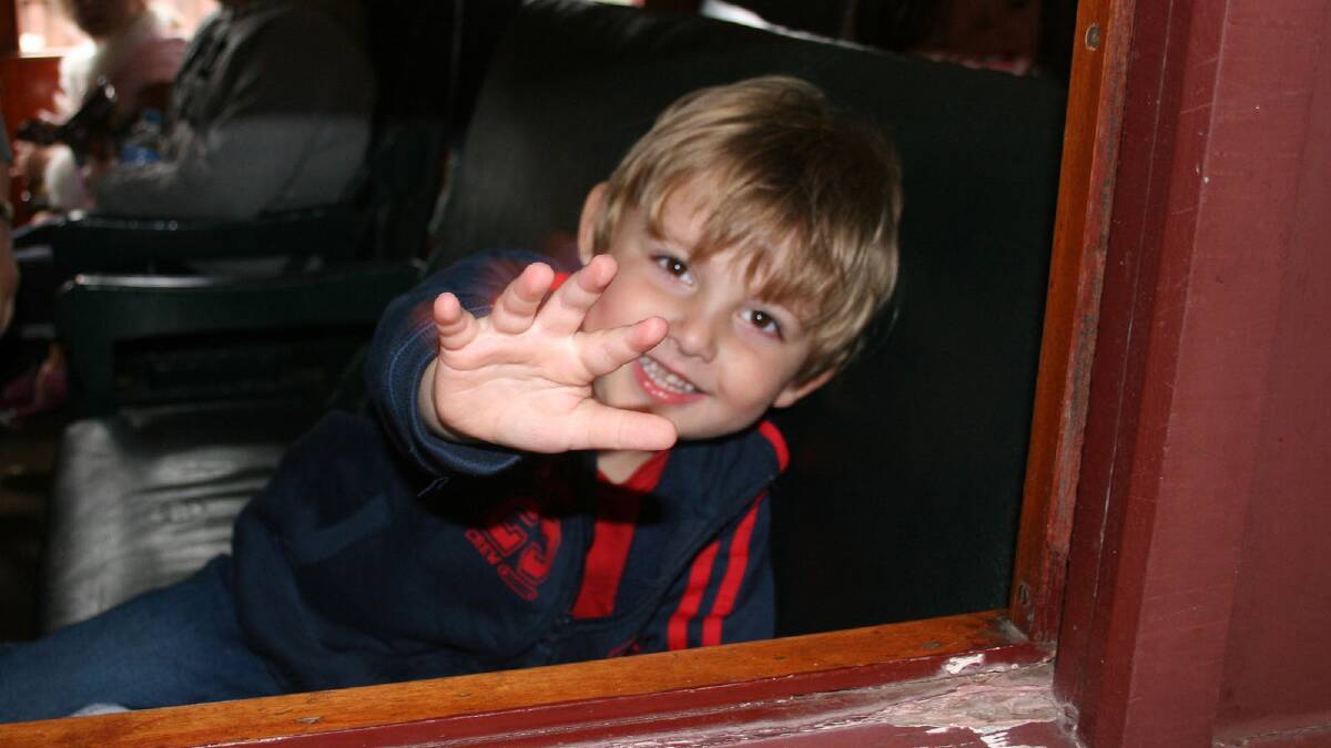 Ethan Kemp, 3, waves from the window.