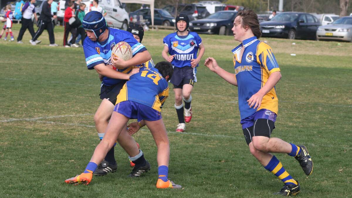 Kauri Deacon (left) tries to bring a Tumut player down with Kyle Dunstall coming into help in Under 14s.
