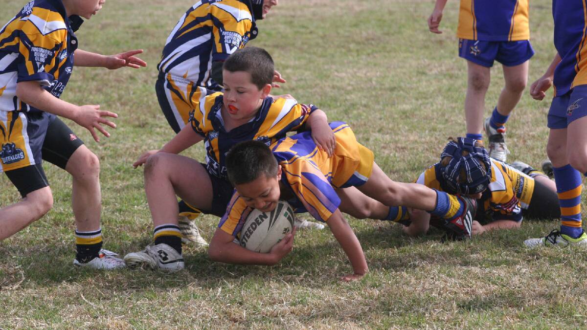 Patrick Tulaga gets tackled in Under 8s.