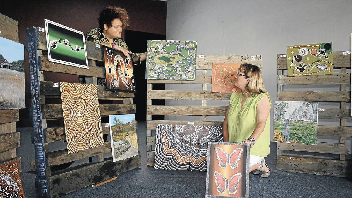 CREATIVE FLAIR: Junee women Judy-Ann Emberson (left) and Jeanne Kennedy show off one of the displays they pieced together of artwork from inmates at the Junee Correctional Centre. Picture: Kree Nash