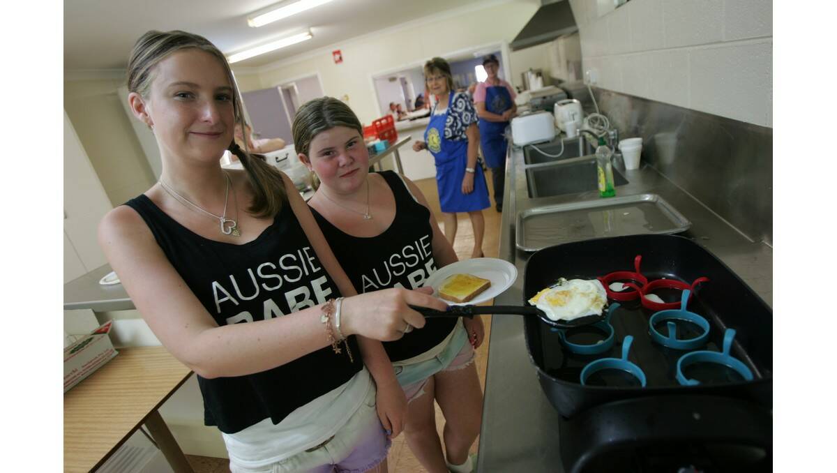 SISTERS Cassie, 16 (left), and Jessica Broadrick, 12, were in charge of toast and eggs at the Yanco Lions Club Australia Day breakfast.