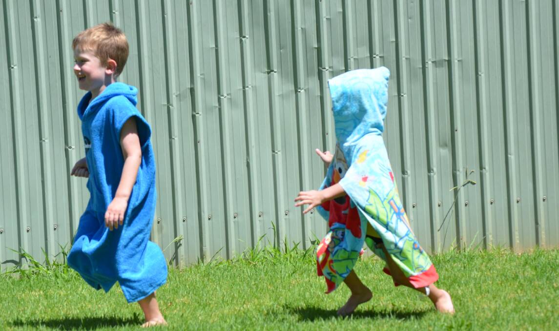 Archie Keough, 5 (left) gets chased by Tom Shumack, 4. Australia Day in Junee. Picture: Declan Rurenga