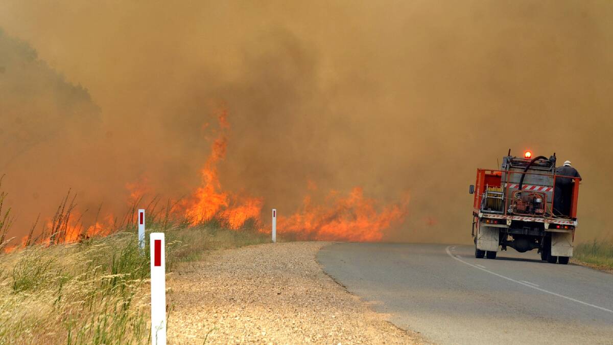 Firefighters work hard to control the blaze as it travels quickly near Oura. Picture: The Daily Advertiser