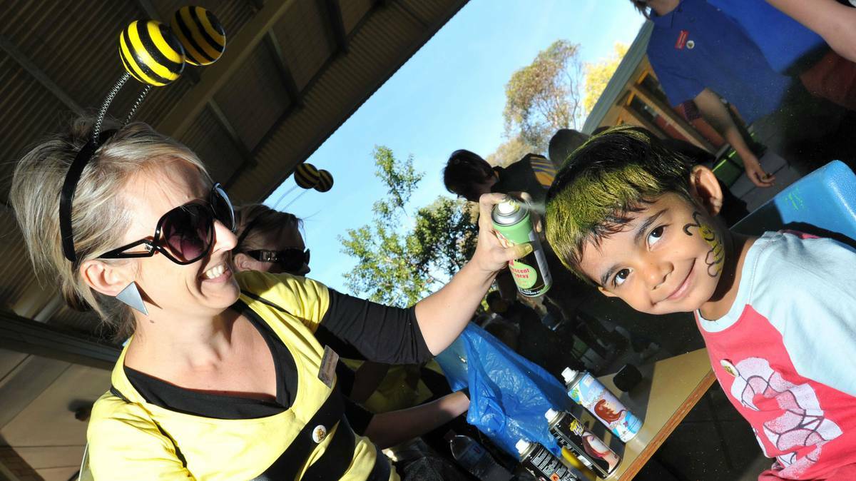 Archie King, 4, has his hair coloured by 'busy bee' teacher Amanda Shepherd during the launch of a special behaviour program at Tolland Public School. Picture: Riverina Leader