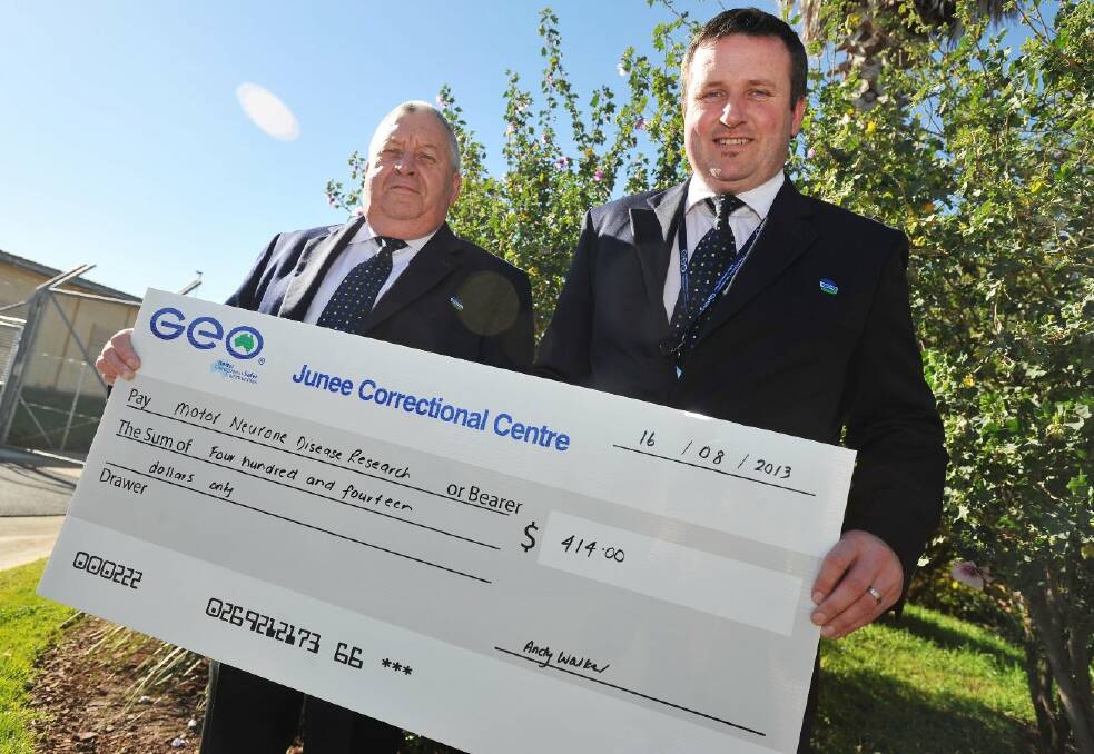 Jason Flagg (right) receives a cheque from Junee Correctional Centre general manager Andy Walker. GEO Group has donated to Mr Flagg’s walk from Wagga to Barmedman in support of motor neurone disease research. Picture: Alastair Brook