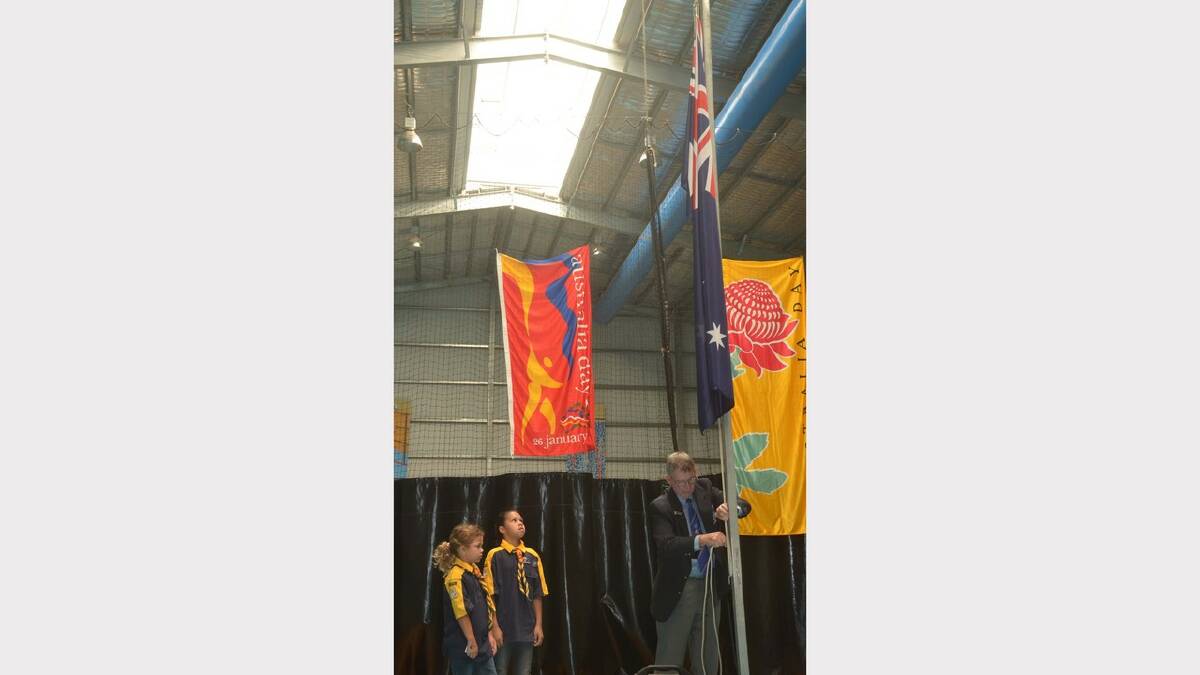 Natasha, 10, and Tootsie Lamb 8 with RSL sub-branch president John Robertson raising the flag during Australia Day. Picture: Declan Rurenga