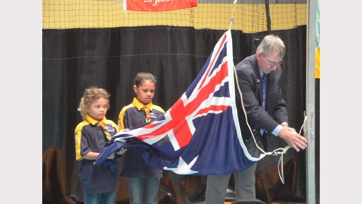 Natasha, 10, and Tootsie Lamb 8 with RSL sub-branch president John Robertson raising the flag during Australia Day ceremony. Picture: Declan Rurenga
