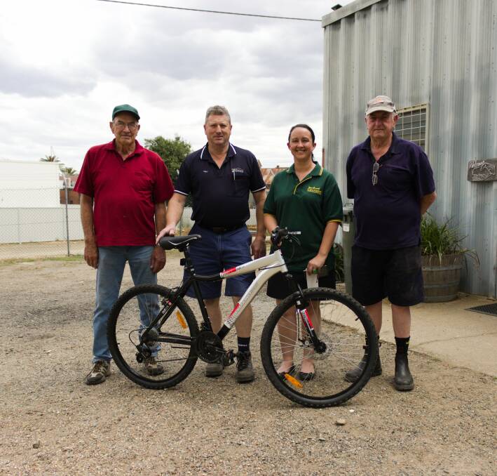 Gary Martin collects his bike from Men's Shed members George Burgess (left) and Barry Brain (right), with CanAssist's Natalie Phillips. Picture: Emma Horn