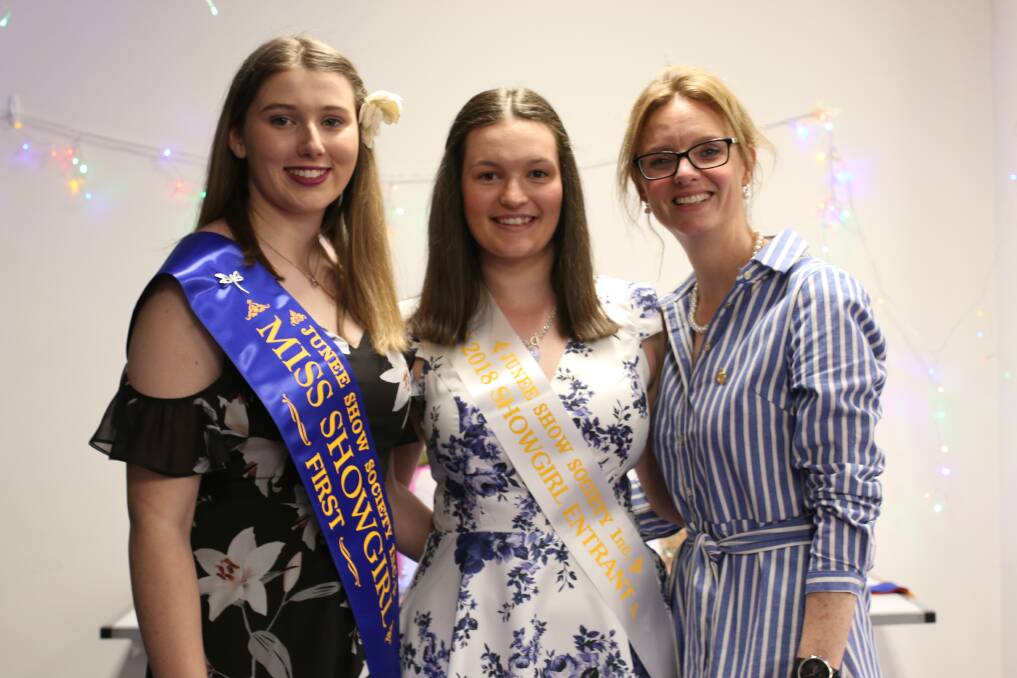 THE BATON: Incoming showgirl Teagan McCormack, presented by her predecessor Hannah Turner and Steph Cooke on Saturday night. Picture: Emma Horn