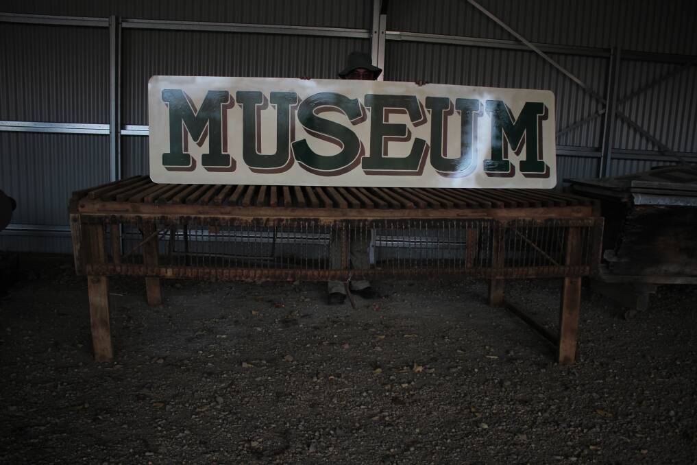 NEW HISTORY: The museum's new signs have arrived, along with several exhibition items including the wool table pictured beneath the sign. Picture: Emma Horn