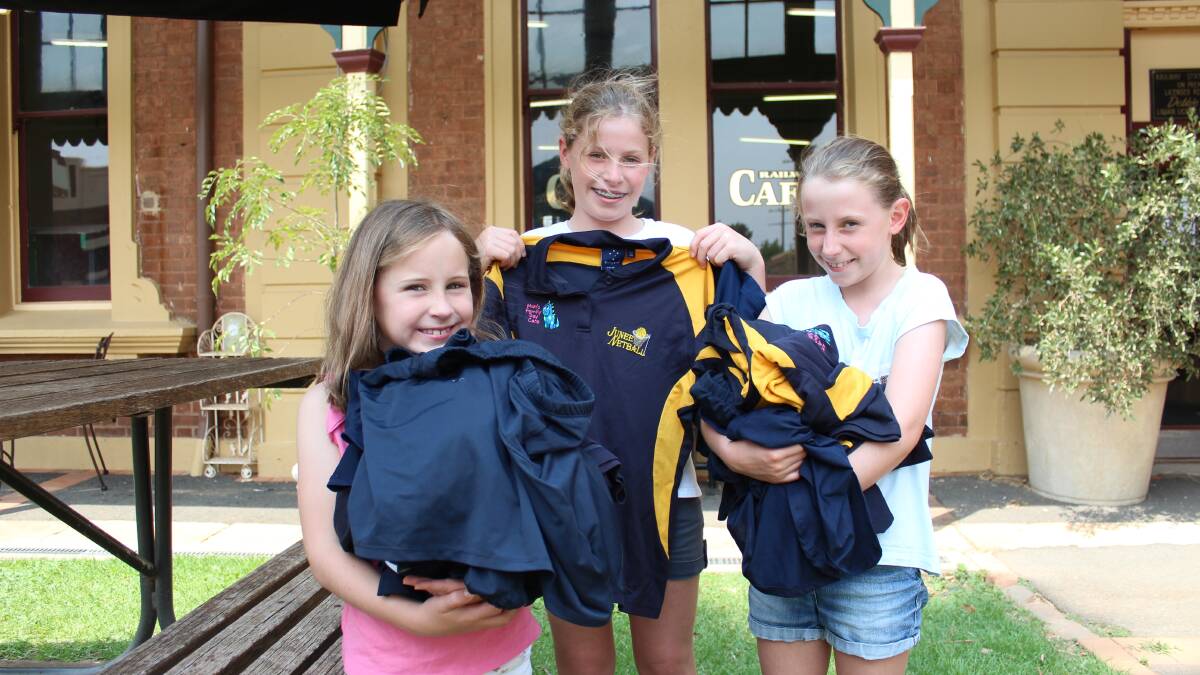 SPORT SUPPORT: Harriet Corbett aged 7, Jocie Corbett aged 11 and Poppy Corbett aged 10, with stacks of old uniforms to donate to the South Coast fire appeal. Picture: Emma Horn