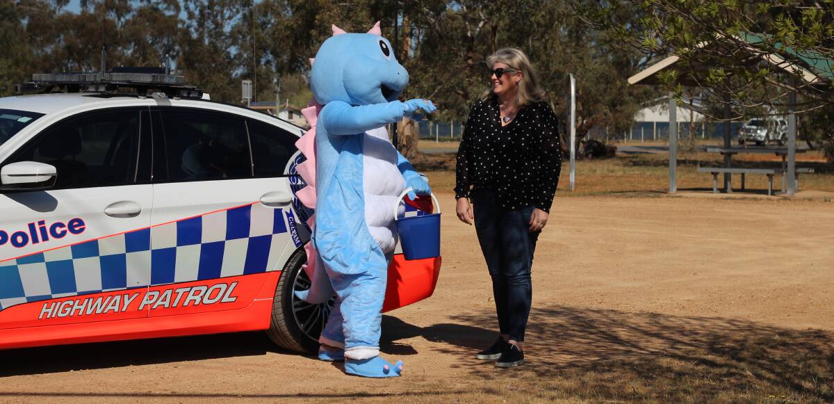 DINO DRIVER: Glenn Sheehan, dressed as the foundation mascot, goes in for the hug with Little Blue Dinosaur founder Michelle McLaughlin during the Old Junee launch.