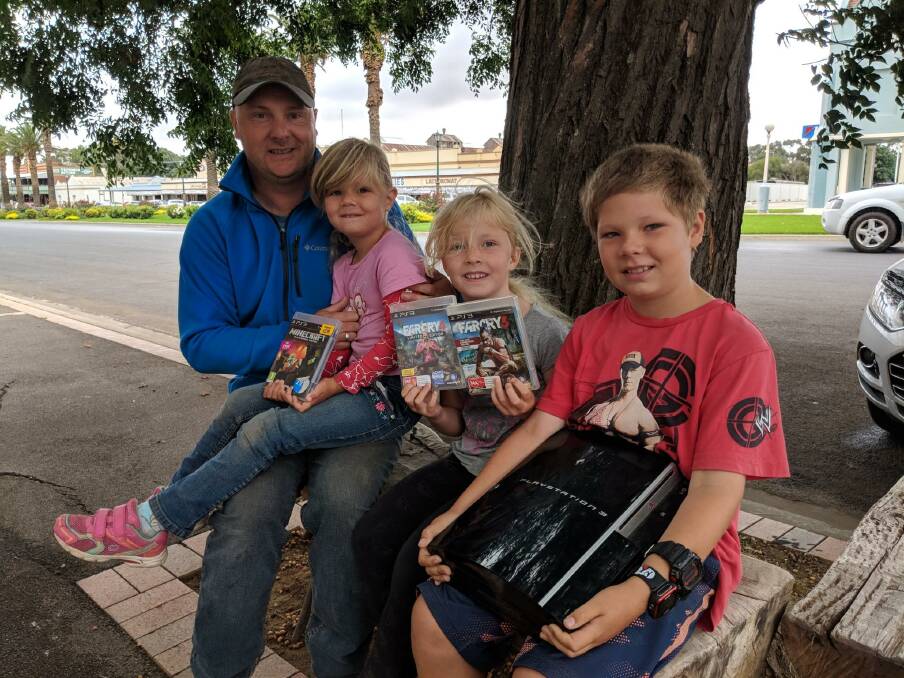 HEART GIFTS: Hamish 8, Matilda 7, Maeryn 5, and dad Jay Doonan giving the family's XBox to Junee's Community Centre. Picture: Emma Heard