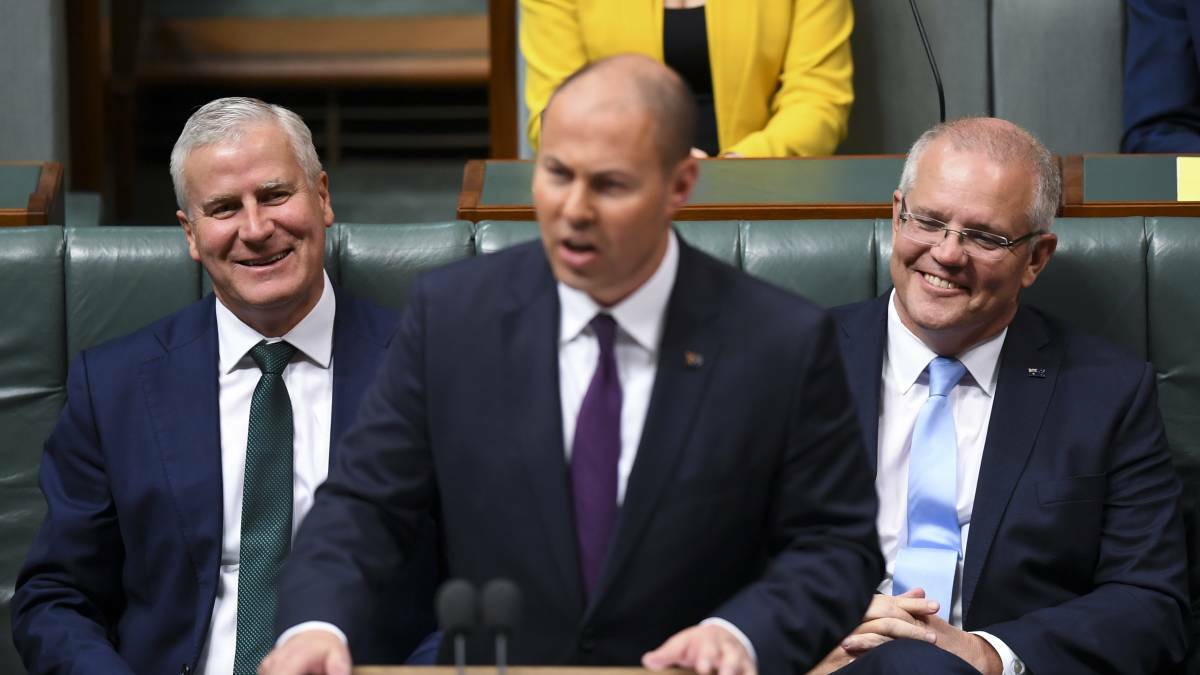 Deputy Prime Minister Michael McCormack (left) and Prime Minister Scott Morrison (right) react as Treasurer Josh Frydenberg speaks at the dispatch box during the delivery of the 2019-20 Budget in Parliament on Tuesday. Picture: AAP/Lukas Coch
