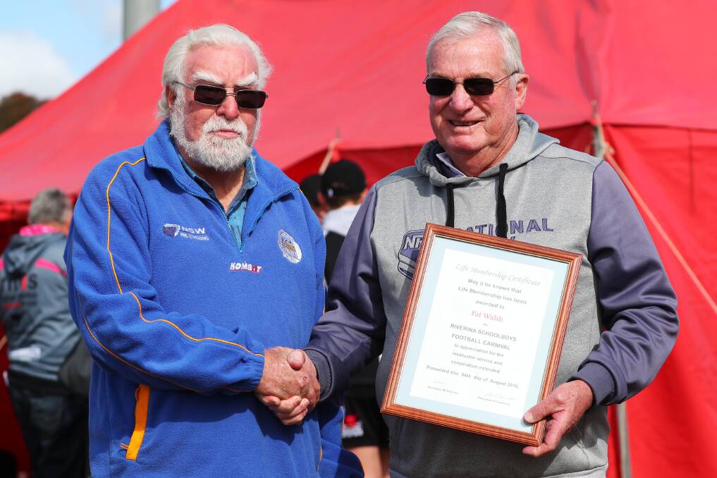 MVP: Schoolboys president Phil Cummins congratulates Pat Walsh for his four decades of service to the nation's referees. Picture: Emma Hillier