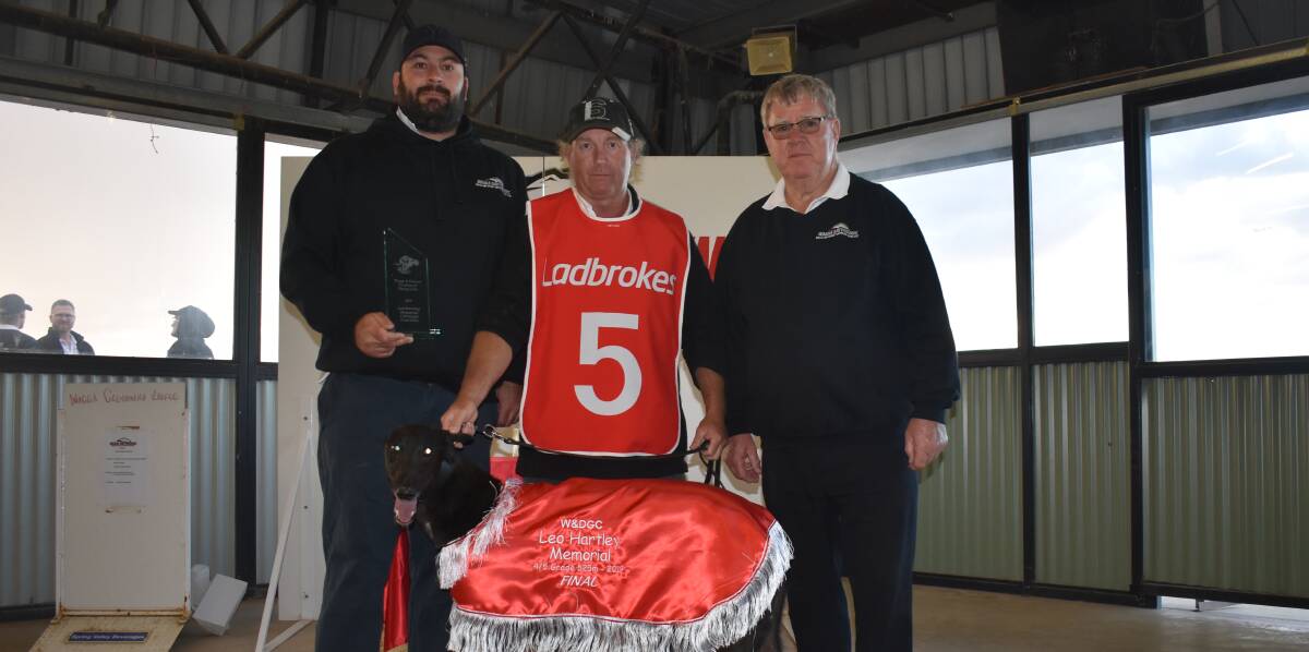 SURPRISE RESULT: Owner Shane Felke and trainer Alan Clare are presented with the spoils off success by John Hartley after Shiny Rose took out the Leo Hartley Memorial on Friday night. Picture: Courtney Rees