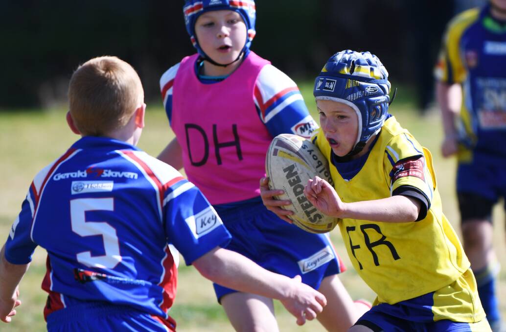 DETERMINATION: Junee's Finn Hillam powers into his opponents from Canberra club South Tuggeranong during last year's Riverina Schoolboys Football Carnival. 