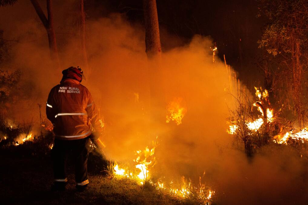 LOCAL HEROES: A brave fire fighter battles a blaze in Belmont during the horrific 2019/20 Black Summer fire season. Photo: NSW Rural Fire Service.