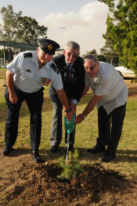 Squadron leader and vice-president of the Junee RSL sub-branch, Peter Hogarth, president of the Junee RSL Sub-Branch, John Robertson, and president of the Junee Ex-Services club, Bill Hulm finish planting the tree in rememberance. Picture: Graham Besley 